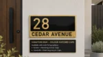Black and gold Signature acrylic house number sign reading 28 Cedar Avenue, with four colour-matched fixing caps.